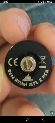 A kézben tartott, fekete fém objektum, amelyen a Dead Rabbit MTL 2 RTA felirat olvasható. (Feliratozva AI-val)