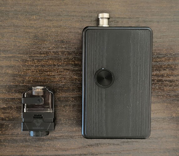 A black electric vaporizer device and its transparent cartridge are visible side-by-side on a wooden surface. (Labeled with AI)