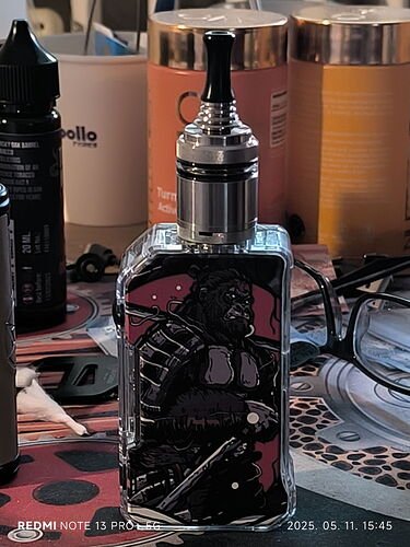 On the table stands a black, patterned vape device, surrounded by various chemicals and liquids. (Labeled by AI)