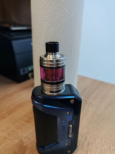 In the picture, a black vape device is visible on a table, with a white paper towel in the background. (Subtitled by AI)