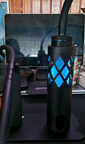 In the foreground stands a black hookah decorated with blue details, and a laptop is visible in the background. (Transcribed by AI)