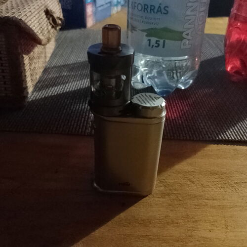 A e-cigarette and a 1.5 liter PANNONIA mineral water bottle are visible on the table. (Subtitled with AI)