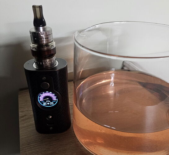 On the table is a black e-cigarette and a partially filled bottle. (Labeled by AI)