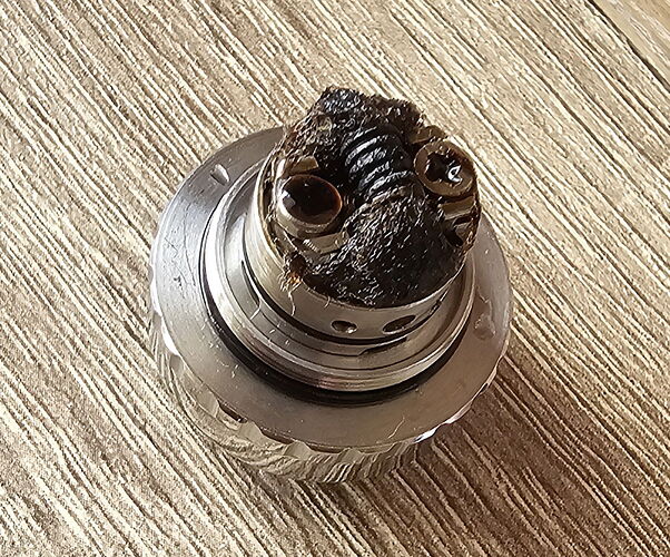 A képen egy elhasználódott és megégett vaporizátor alkatrész látható. (Feliratozva AI-val)