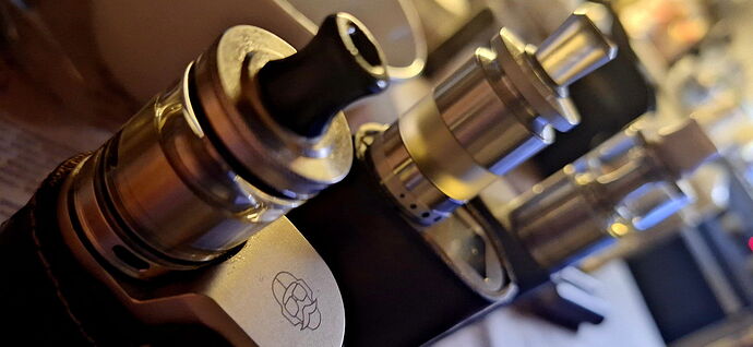 Az image egy vape készüléket és két különböző tankot mutat be. (Feliratozva AI-val)