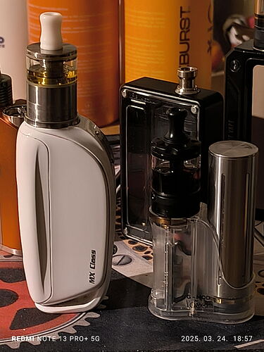 A képen különböző vape készülékek láthatók, többek között egy fehér színű készülék és egy átlátszó tartály. (Feliratozva AI-val)