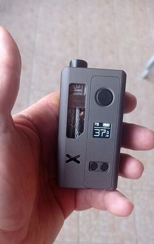 Egy kéz egy kis elektronikus dohányzóeszközt (elektromos cigarettát) tart, amelynek kijelzőjén 37.0 W teljesítmény látható. (Feliratozva AI-val)