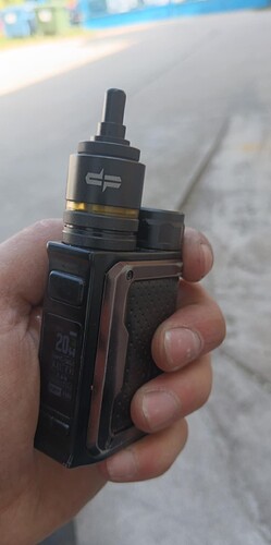 Egy ember kezében egy fekete és ezüst színű elektromos cigaretta (vape) van. (Feliratozva AI-val)