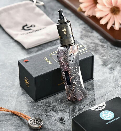 Un appareil de vape électrique à motifs posé sur une boîte noire, avec un sac en toile et une fleur en arrière-plan. (Légendé par IA)