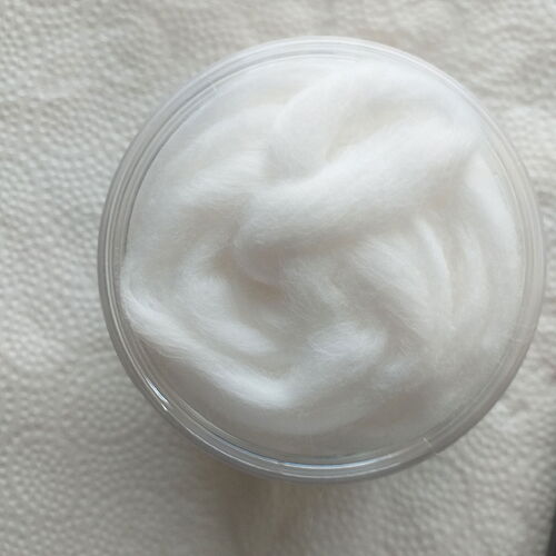 Une image montrant des boules de coton blanc dans un récipient transparent. (Légendé par l'IA)