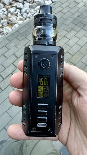 Une cigarette électronique noire (vape) tenue dans la main est visible, dont l'écran affiche une température de 45,0°C et d'autres données. (Légendé par IA)