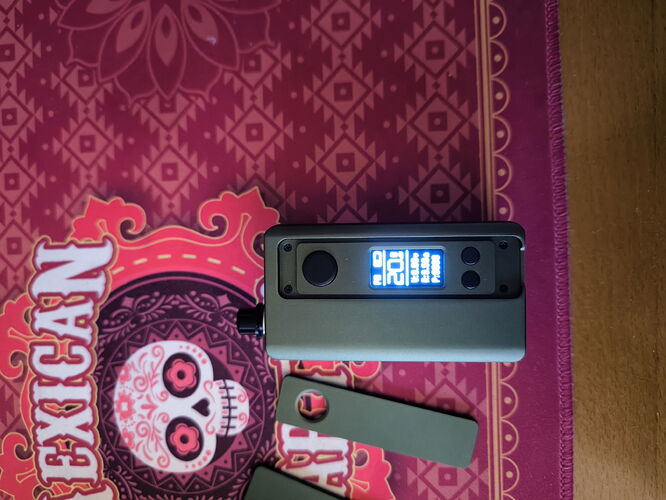 A more modern vaporizer is shown in the image, lying on a colorful patterned rug. (Autogenerated by AI)