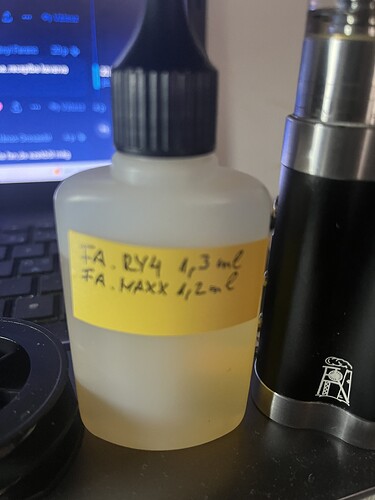 A plastic dropper bottle with a label and an electronic cigarette or vaporizer device is visible next to a laptop keyboard. (Labeled by AI)