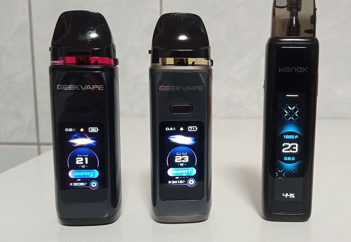 Three modern, black, illuminated display pod-type e-cigarettes stand next to each other on the table. (Subtitled by AI)