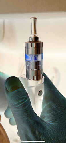 Egy kéz egy elektromos cigarettát tart egy világos háttér előtt, a kép negatív színmódban van megjelenítve. (Feliratozva AI-val)