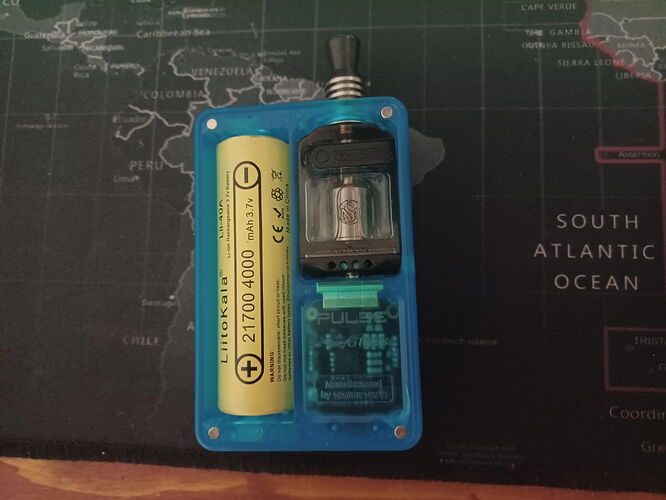 The image shows a device with a blue transparent plastic casing, containing a yellow ELEAF IMR 21700 4000 battery and what appears to be a smoke grenade or electronic components. (Captioned by AI)