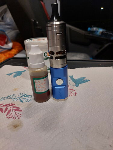 A picture shows an e-cigarette and a small dropper bottle on a table. (captioned by AI)