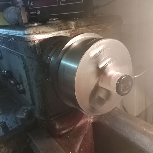 The image shows a lathe with a rotating metal object being machined. (Subtitled by AI)