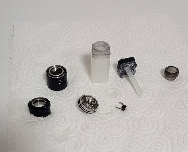 Az image egy papírkendőn szétszedett elektronikus cigaretta vagy vaporizáló alkatrészeit ábrázolja. (Feliratozva AI-val)