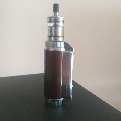 Un appareil de vape argenté et marron avec un réservoir en verre est représenté sur l'image. (Légendé par l'IA)