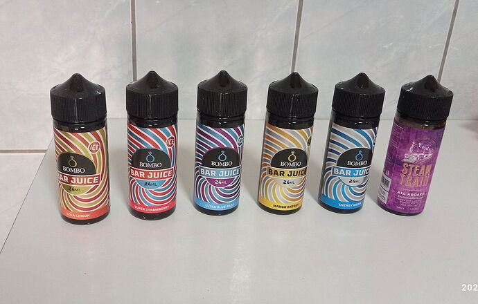 Az imént bemutatott képen különböző ízesítésű vape folyadékok láthatók, mind színes palackokban. (Feliratozva AI-val)