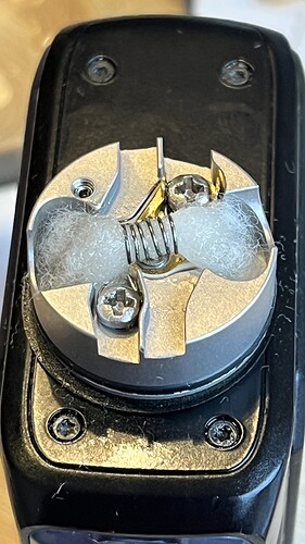 A kép egy gőzölő patron belsejét mutatja, ahol egy ellenálláshuzal és pamut látható. (Feliratozva AI-val)