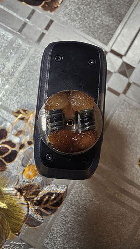 Az image egy felülről készült kép egy elektromos eszközről, amelyben látható egy feltekeredett fűtőtekercs és szigetelőanyag maradványok. (Feliratozva AI-val)