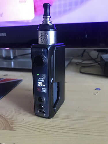 Une cigarette électronique noire (vape) est sur la table, avec une puissance de 25 watts réglée. (Légendé par IA)