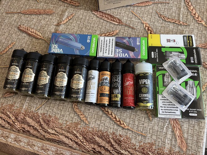 Several bottles of aroma oil and vape accessories in different packaging are seen arranged side by side on the table. (Subtitled by AI)