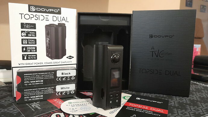 L'image montre un appareil de cigarette électronique Dovpo Topside Dual et ses boîtes, accessoires. (Légendé par IA)