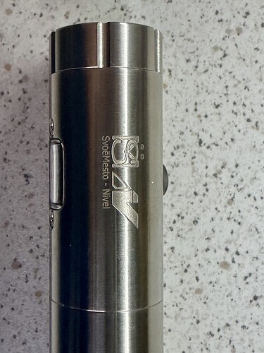 Az képen egy fém zseblámpa látható, amelyen a "SAY" felirat és a márka logója is megtalálható. (Feliratozva AI-val)