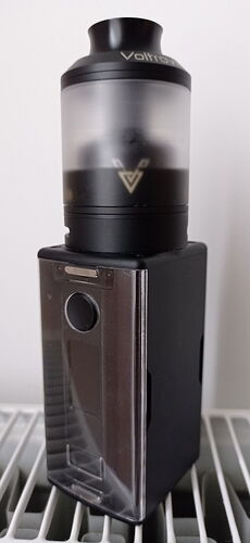 A black vape device with a colorless tank on top. (Caption by AI)