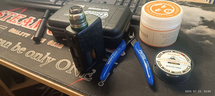 An e-cigarette setup is placed on a table, which includes a vape mod, blue pliers, coiled wire, and cotton. (Labeled by AI)