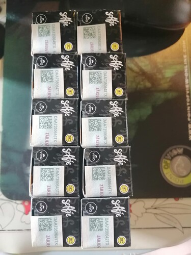 A képen Vivo márkájú, fekete színű dobozok láthatók sorokban elrendezve, rajtuk Selfie felirat, QR kódok és egyéb azonosítók. (Feliratozva AI-val)