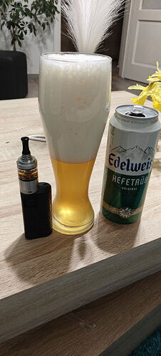 Une bouteille de bière, une canette de bière et un vape se trouvent sur la table. (Légendé par l'IA)