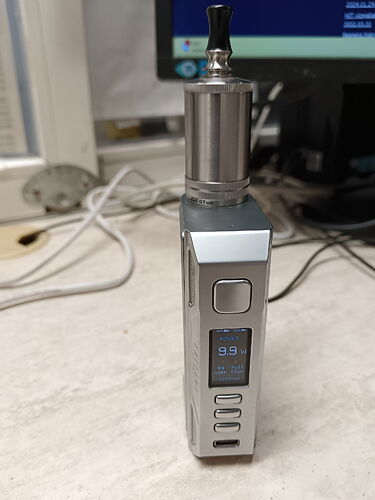 On voit un vaporisateur de couleur argentée avec un écran numérique et un réservoir en métal. (Sous-titré par IA)