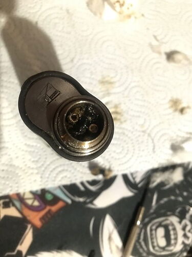 A burnt or scorched metal part is visible on a paper towel and a small metal tool. (Captioned by AI)