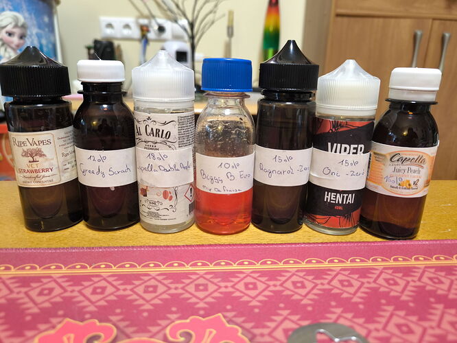 Sept flacons d'e-liquide de différentes tailles et couleurs sont alignés sur une surface à motif rose. (Légendé par IA)