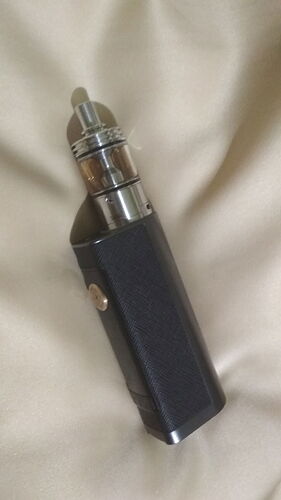 Egy fekete elektromos cigaretta egy világos anyagon van elhelyezve. (Feliratozva AI-val)