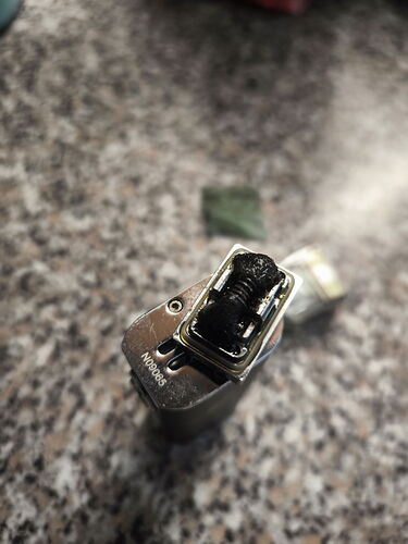 A close-up of a metal lighter, with its top in the center of the image on a kitchen countertop. (Labeled by AI)