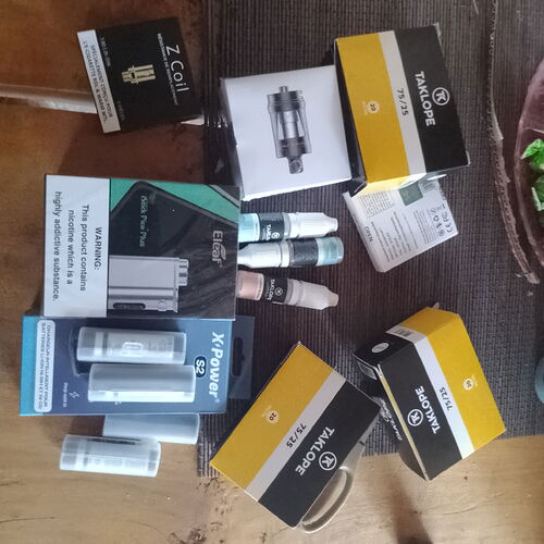 Various accessories and boxes belonging to electronic cigarettes are spread out on the table. (Subtitled by AI)