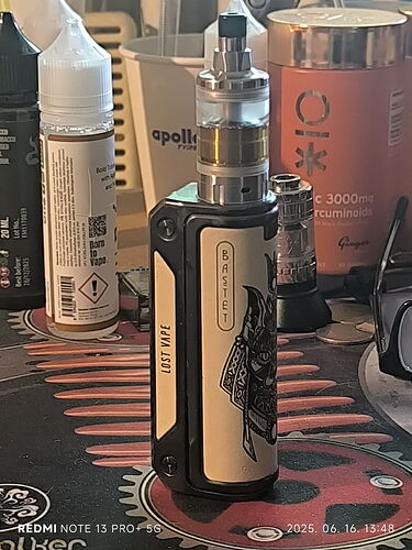 On the table is a black and white designer electric cigarette (e-cigarette), with various bottles and other small objects visible around it. (Labeled by AI)