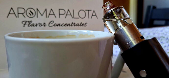 Un mug de café et une cigarette électronique sur une table, avec une boîte intitulée "AROMA PALOTA Flavor Concentrates" en arrière-plan. (Sous-titré par IA)