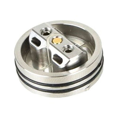 This is a metal part, likely part of a mechanical or electronic device, with a circular base and two holes. (Annotated by AI)