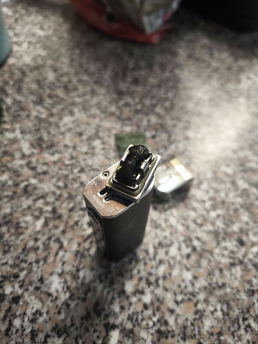 A partially burnt black USB flash drive is on the table. (Labeled by AI)