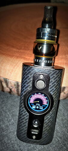 In the picture, a black, stringed vape device is visible, which has a digital display and a colored meter. (Labeled by AI)