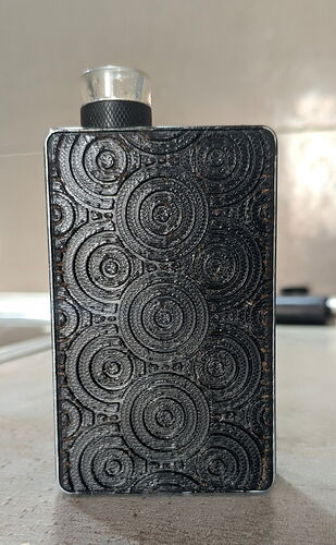 The image shows a black candle holder with a paw print decoration on a light surface. (Captioned by AI)