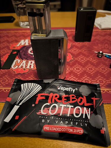Az képen egy Vape készülék és egy csomag Vapefly Firebolt pamut látható, amely 20 előre töltött darabot tartalmaz. (Feliratozva AI-val)