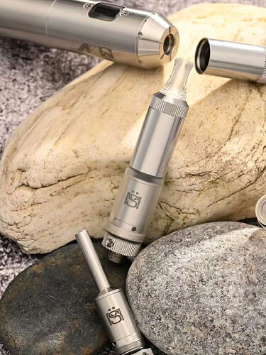 Sur la photo, plusieurs pièces métalliques de cigarette électronique sont visibles, placées parmi des pierres de différentes couleurs. (Légendé par IA)