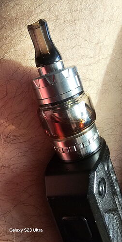 A képen egy modern e-cigaretta látható, amely fémből és üvegből készült tartályból áll. (Feliratozva AI-val)